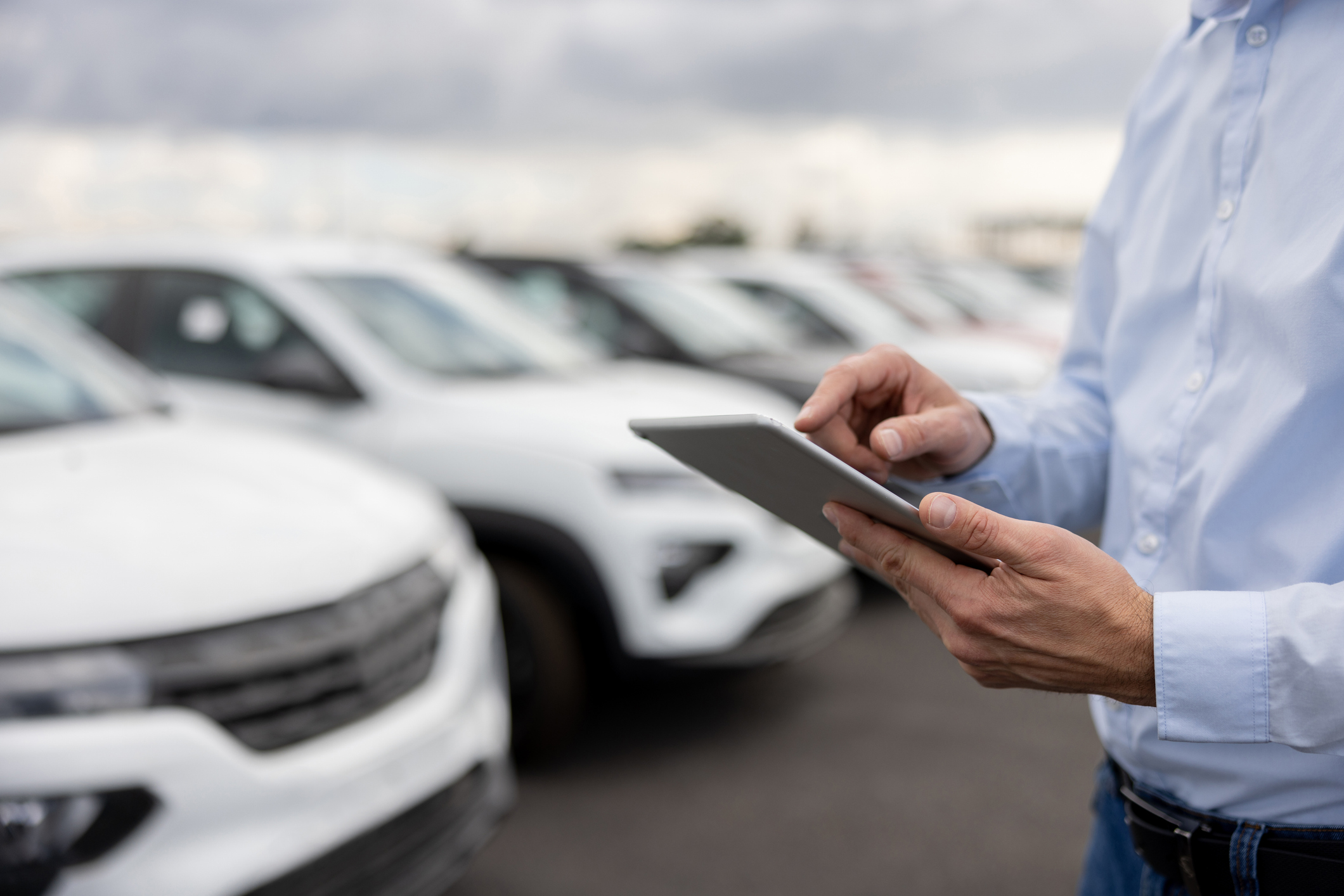 Close-up on a car salesperson using a tablet computer